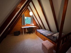 a attic room with a bed and a desk at Ferienhaus Amrhein in Siegsdorf