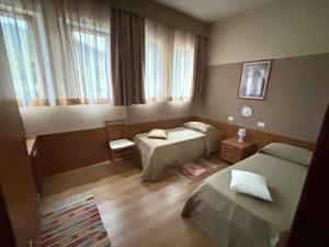 a bedroom with two beds and a window at Locanda Chiocciola By Manuel Ronzani in Quero