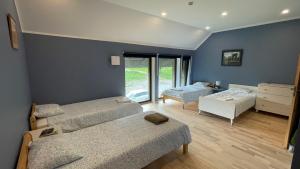 a bedroom with two beds and a room with a window at Kipeni Guest House in Limbaži