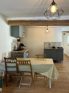a dining room with a table and chairs and a kitchen at Chambres d'hôtes de l'encabanée in Saint-Paul