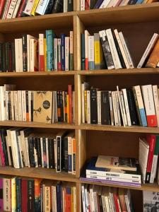 a book shelf filled with lots of books at Chambres d'hôtes de l'encabanée in Saint-Paul