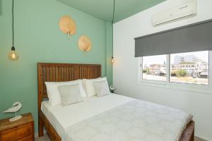 a bedroom with a white bed and a window at Olive Grove Apartments in Larnaca