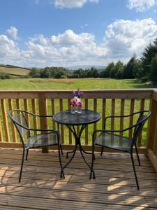 a table and two chairs on a deck at Hill View Glamping Hut in Tregaron +5 photos