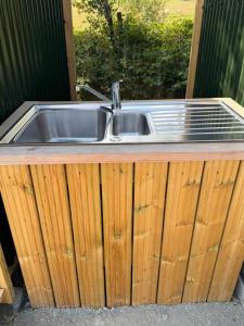 a kitchen sink on a wooden counter top at Hill View Glamping Hut in Tregaron