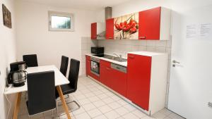 a kitchen with red cabinets and a table with chairs at Gartenparadies mit Rheinblick in Urbar in Urbar +9 photos