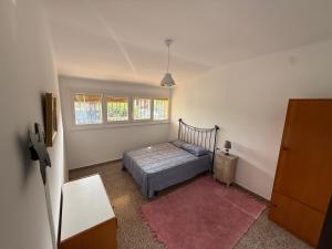 a bedroom with a bed and a dresser and window at Casa con encanto en Darnius in Darnius