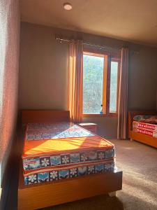 a bedroom with a bed and a window at Marvoi resort in Hunza Valley