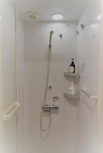 a bathroom with a shower with a hose on the wall at Villa Kyoto Saiin in Kyoto
