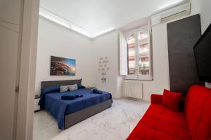 a bedroom with a bed and a red couch at Sogno Di Mezzanotte in Taranto