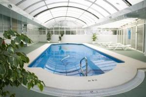 a large swimming pool in a building with a ceiling at Aparthotel BCL Levante Club in Benidorm