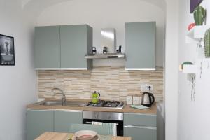 a kitchen with white cabinets and a stove at Sogno Di Mezzanotte in Taranto