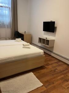 a bedroom with two beds and a flat screen tv at Hotel Park Drniš in Drniš