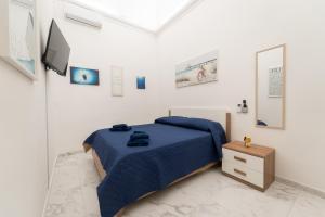 a bedroom with a blue bed and a tv at Sogno Di Mezzanotte in Taranto
