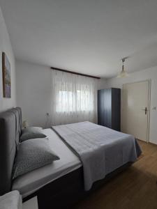 a bedroom with a large bed and a window at Guest House Olbina in Korenica