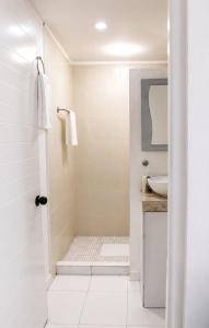 a white bathroom with a shower and a sink at Ocean Bloom in Cancún +13 photos