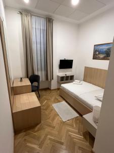 a hotel room with two beds and a television at Hotel Park Drniš in Drniš