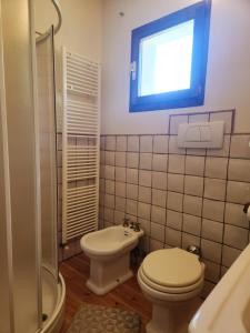 a bathroom with a toilet and a sink and a window at Appartamento Sotto la Riva in Abetone