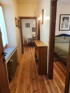 a room with a bed and a wooden floor at Appartamento Sotto la Riva in Abetone