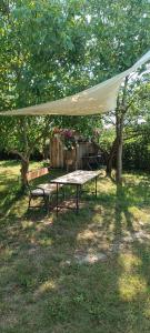a table and a bench under a tent in a yard at Bauwagen Fridolin in Restorf +4 photos
