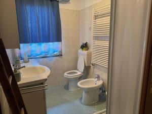 ein Badezimmer mit Toilette und Waschbecken in der Unterkunft Maison Biula in Cerise