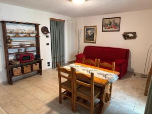 ein Wohnzimmer mit einem roten Sofa und einem Tisch in der Unterkunft Maison Biula in Cerise + 7 Fotos