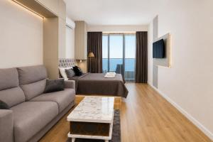 a living room with a couch and a bed at Mayak Bamboo Beach Apartments in Kobuleti