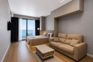 a living room with a couch and a bed at Mayak Bamboo Beach Apartments in Kobuleti