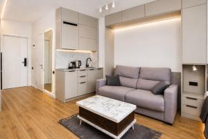 a living room with a couch and a table at Mayak Bamboo Beach Apartments in Kobuleti