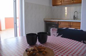 a table with two cups and a plate of food on it at Blazo jedan in Neviđane