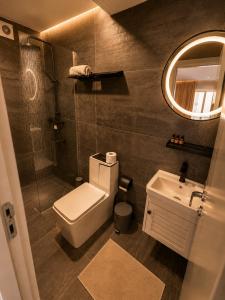 a bathroom with a toilet and a sink and a mirror at Boutique Hotel Bora in Peje