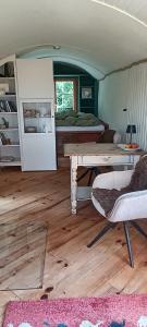 a living room with a table and a bed at Bauwagen Fridolin in Restorf