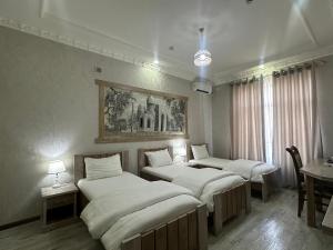 a room with three beds in it with a table at Ideal Hotel in Samarkand +74 photos