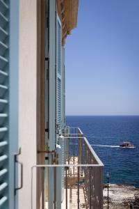 a balcony of a building looking out at the ocean at EGEO - Ortigia in Syracuse +48 photos