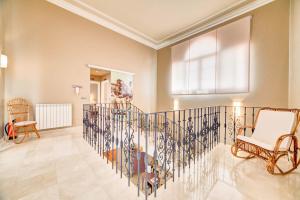 a living room with a staircase with a white chair at Ver Venir, acogedoras habitaciones con piscina in Garínoain