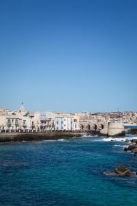 a view of a river with buildings in the background at EGEO - Ortigia in Syracuse