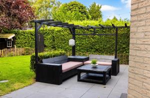 a patio with a couch and a table and a pergola at Weidezicht in Ermelo