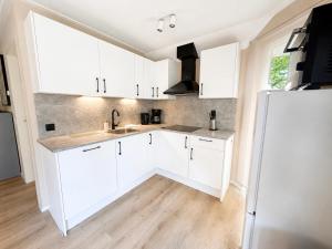 a kitchen with white cabinets and a refrigerator at Weidezicht in Ermelo +18 photos