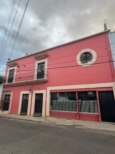 a red building on the side of a street at Hostal Vibes in Oaxaca City