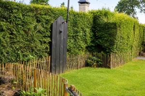 a wooden fence with a wooden door in a yard at Weidezicht in Ermelo