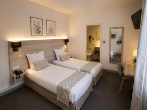 a hotel room with two beds and a mirror at Hôtel L'Alsace Gare-Sncf in Narbonne +57 photos