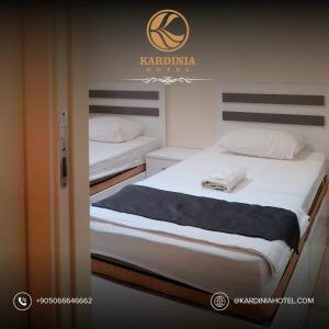 two twin beds in a room with a sign on the wall at Kardinia Hotel in Mezitli