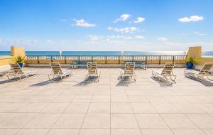 a group of chairs and tables on a patio overlooking the ocean at Boardwalk One in Ocean City
