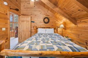 a bedroom with a bed in a log cabin at Hoot n Hollar #31 by Venture Smoky Mountains in Sevierville +80 photos