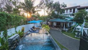 a pool with chairs and umbrellas next to a building at Sea Bloom Villa in Kamburugamuwa