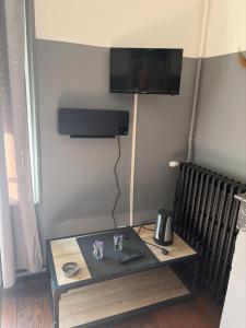 a room with a table with a television on a wall at Gengoult 3 in Toul