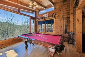 a pool table in a room with a large window at Hoot n Hollar #31 by Venture Smoky Mountains in Sevierville