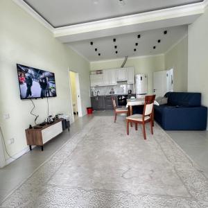 a living room with a table and a blue couch at Атлантис in Chon-Sary-Oy
