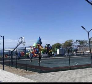 a tennis court with a playground with people on it at Атлантис in Chon-Sary-Oy