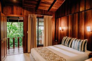 a bedroom with a bed and a large window at Jaguarundi Jungle Lodge - Monteverde in Monteverde Costa Rica