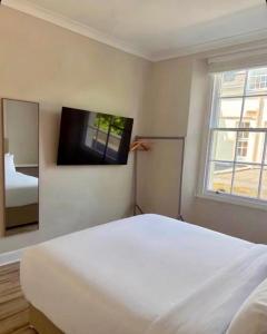 a bedroom with a white bed and a tv on the wall at Central Room to Rent in Plymouth +20 photos